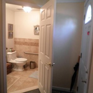 The bathroom was created by using the area which had been a tiny powder room, short hall and coat closet.  It opens into the foyer.  The door on your 