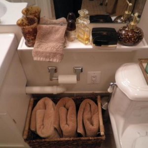 there is 24" between basin and toilet.  Right now we have a narrow shelf (3" deep) to hold some toiletry supplies.  Its a temporary fix as w
