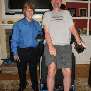 My younger son and dad in his standing chair