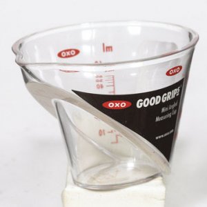 measuring  cup 2 ounce/60 ml.  A great little invention.  You can see the level looking down into it, don't have to hold it up at eye level to be accu